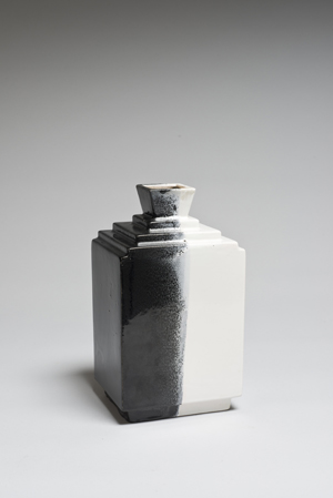 Robert LALLEMANT - Vase quadrangulaire à gradins à col étranglé en céramique émaillée noire et blanche. Signé R.Lallemant. Hauteur : 28 cm